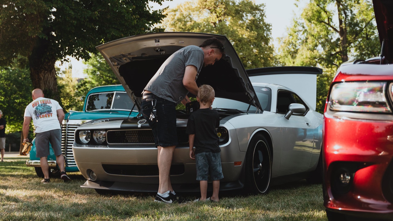 A young car fan checking out an engine bay at Rumble in the Park