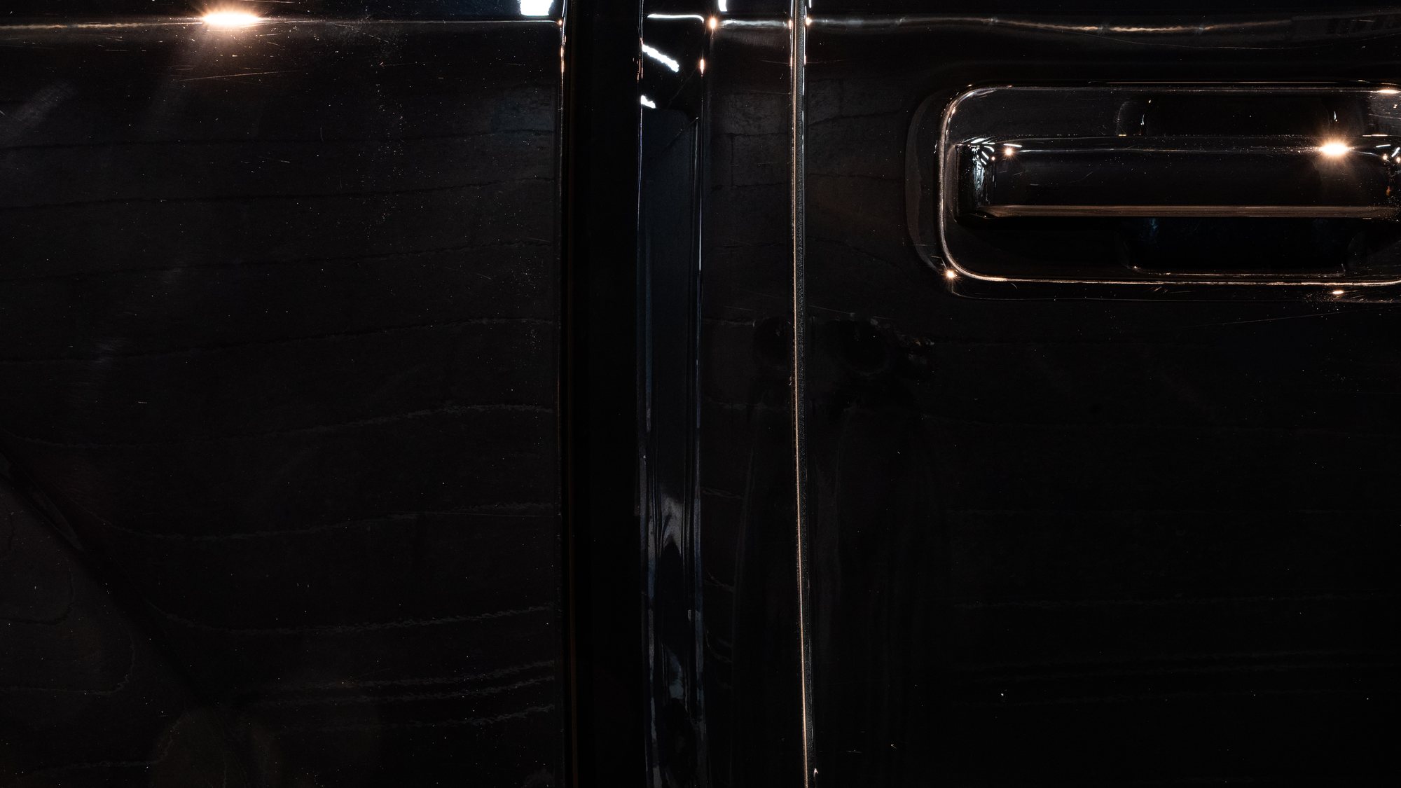 Black door after paint correction, clear reflection