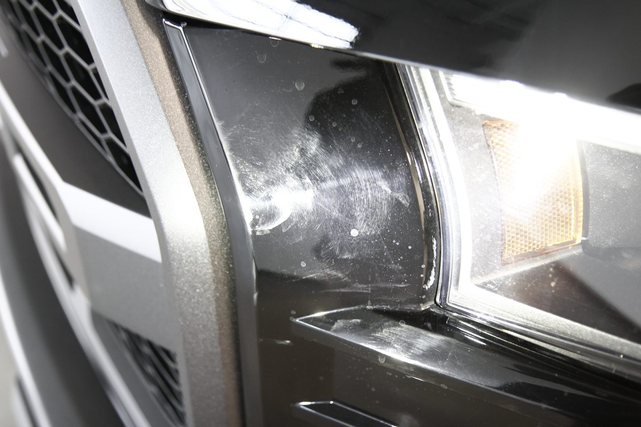 Scratches and marring beside a headlight under inspection light