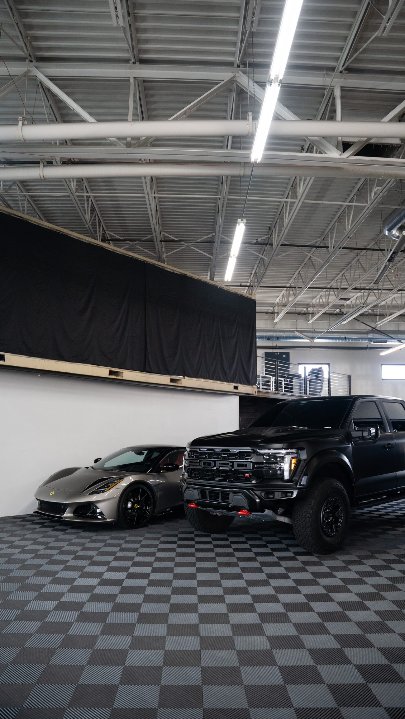 A Lotus Emira and a Ford Raptor R on the LUXE shop floor