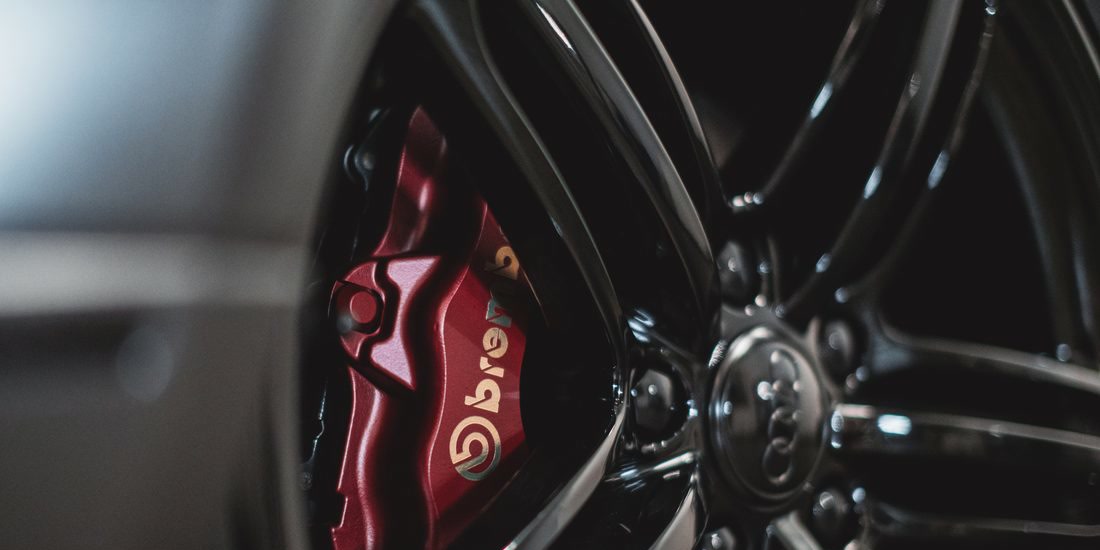 Red Brembo caliper behind a gloss black wheel